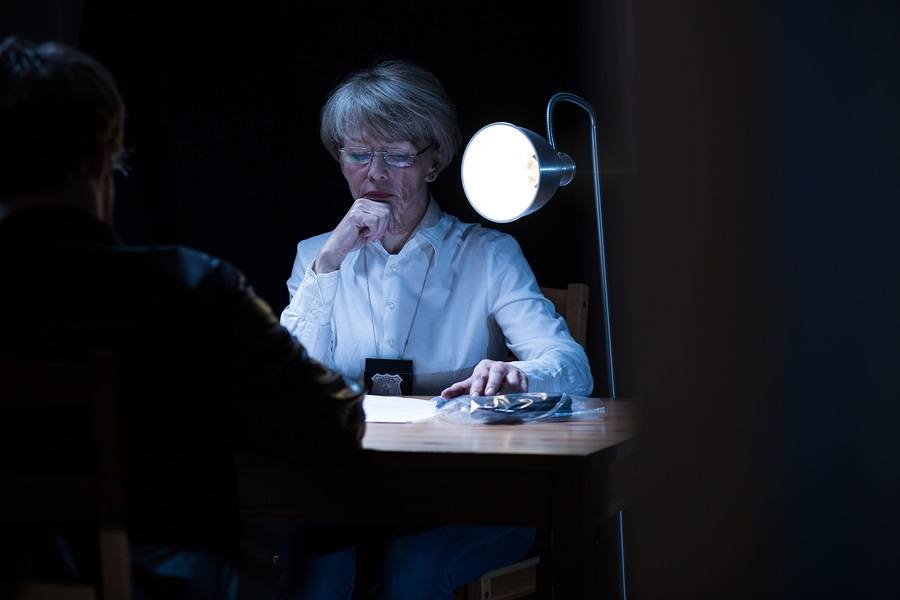 Woman with badge conducting interrogation 