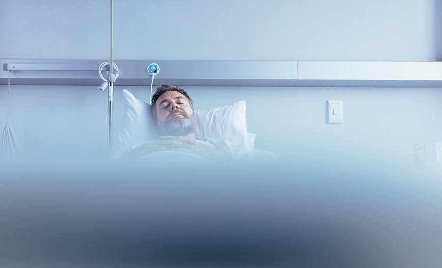 Mature sick male patient sleeping in hospital bed. Patient waiting for his health recovery in hospital ward.